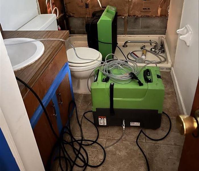 SERPRO equipment being used to handle a broken pipe in a bathroom