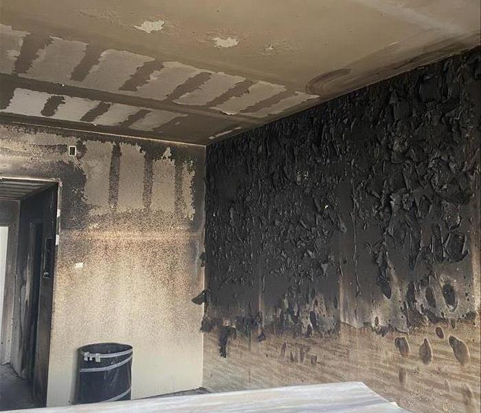 Badly burned interior wall that is black from the flames.